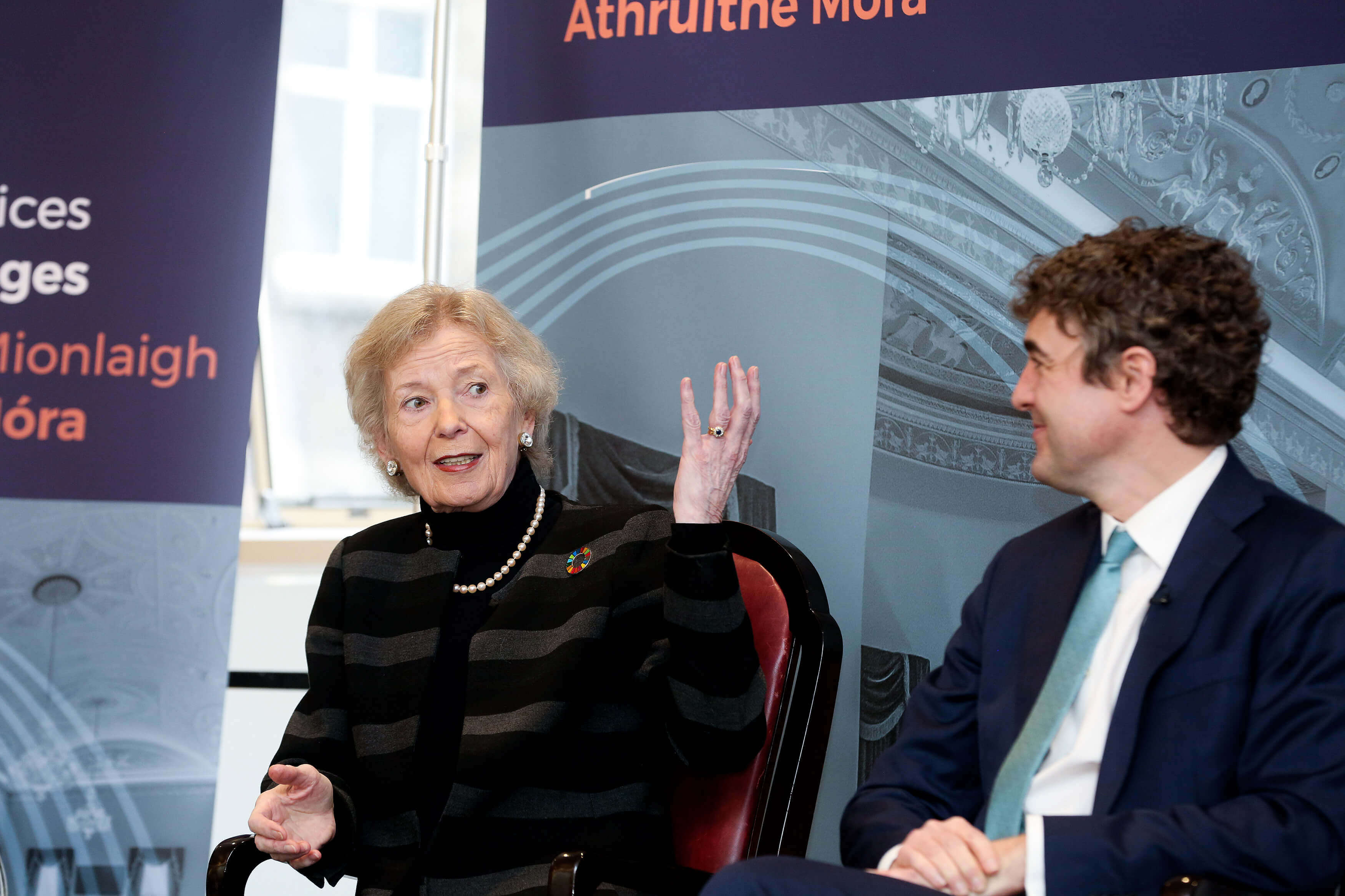 Former President Mary Robinson speaking at an event with the Cathaoirleach, Senator Mark Daly. They are both seated in front of a Seanad100 poster